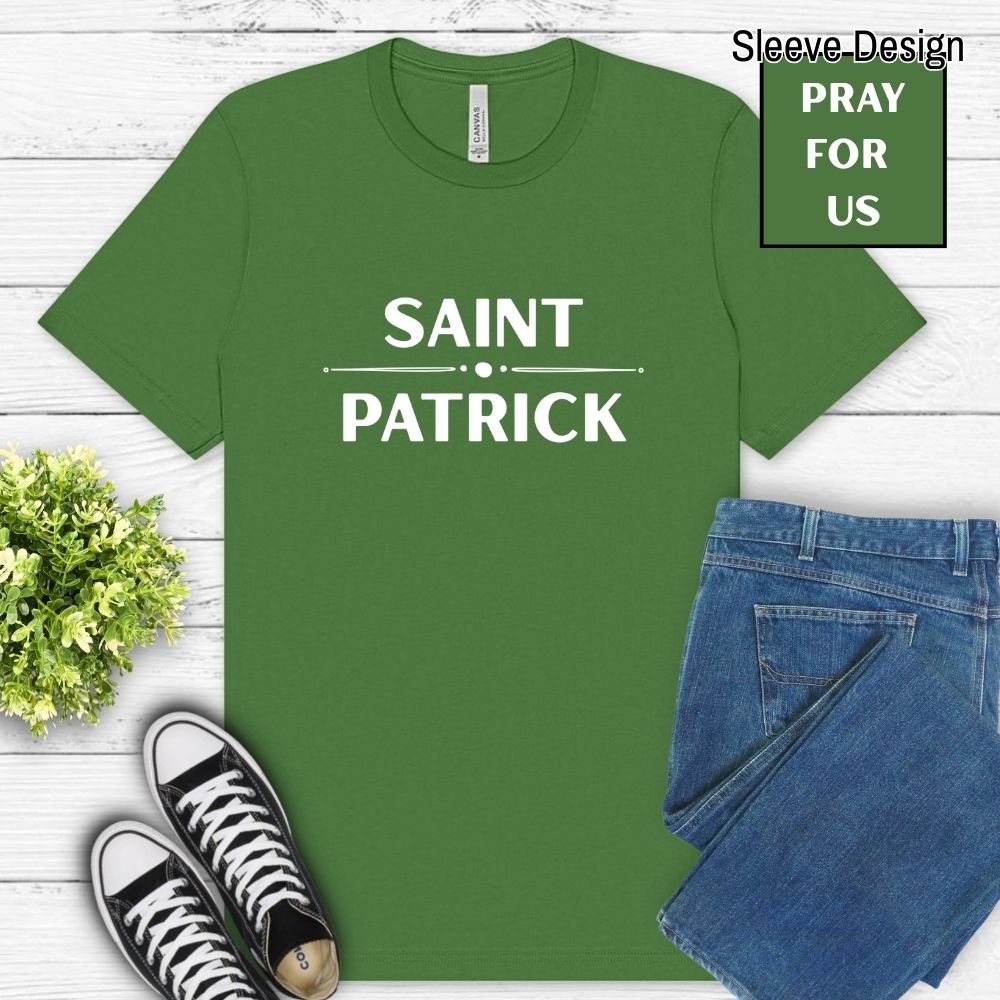 Green t-shirt with 'Saint Patrick' text, black sneakers, and blue jeans on a light wooden surface.