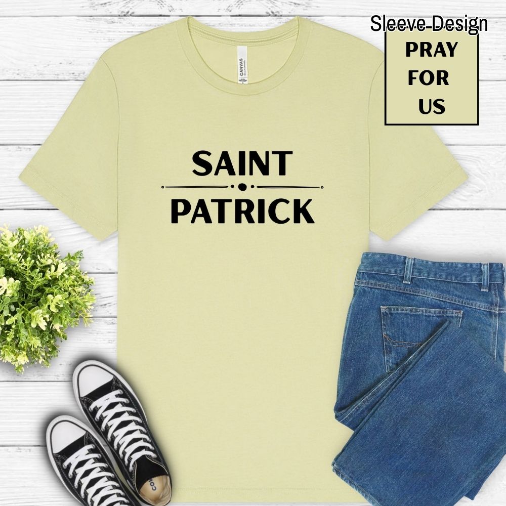 Light yellow-green t-shirt with 'Saint Patrick' text, paired with jeans and sneakers on a wooden surface.